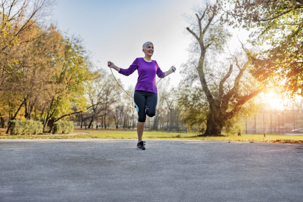 Elderly woman jumping the rope outdoors