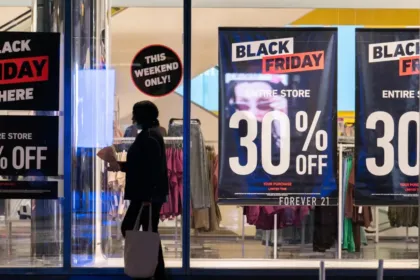 Αγορές σε κατάστημα με Black Friday ταμπέλες και εκπτώσεις.