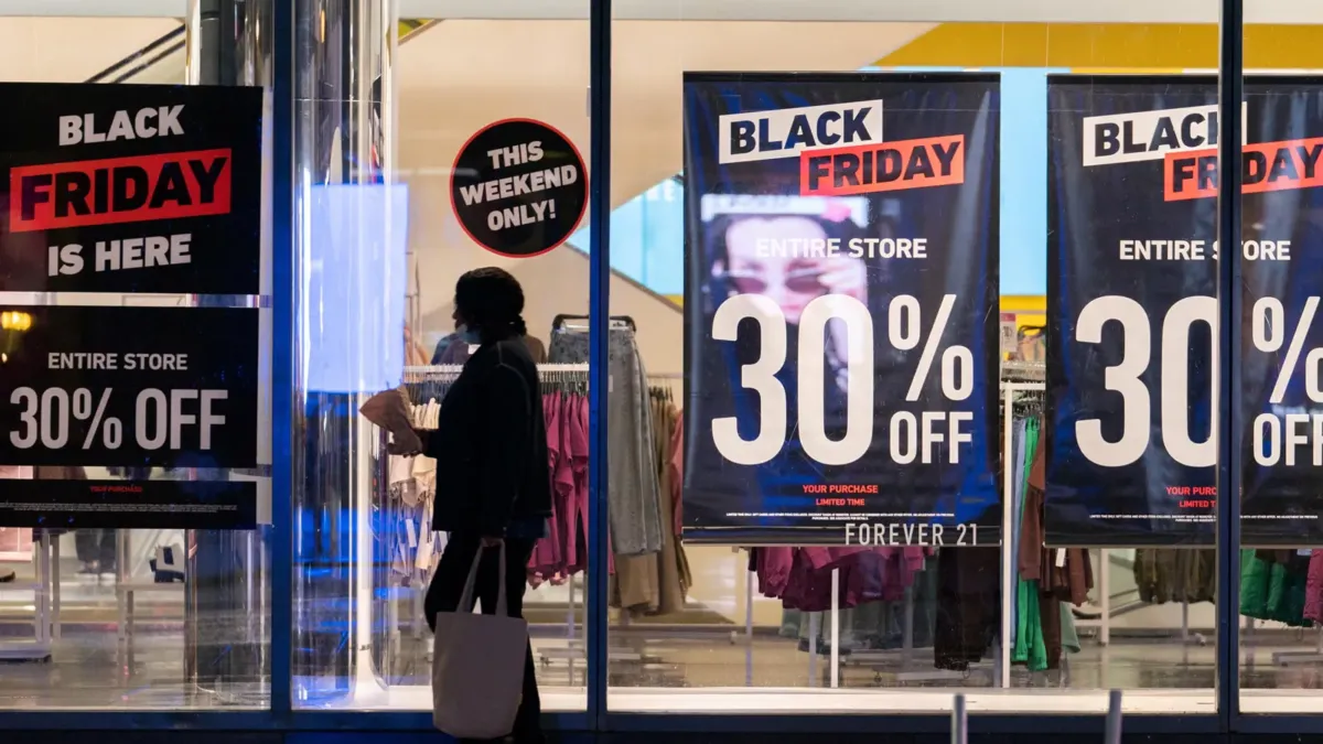 Αγορές σε κατάστημα με Black Friday ταμπέλες και εκπτώσεις.
