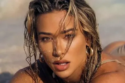 Cindy Prado με trench jacket, δερμάτινο σορτς και animal print clutch σε urban fashion εμφάνιση