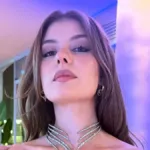 Η Εύη Δαέλη με έντονο μακιγιάζ και λαμπερά χείλη ποζάρει κοιτάζοντας την κάμερα.