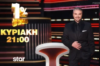 Ο παρουσιαστής Πέτρος Πολυχρονίδης χαμογελαστός στο εντυπωσιακό, φωτισμένο στούντιο του τηλεπαιχνιδιού 1% Club.