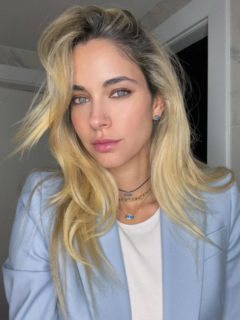 Layering κολιέ με χρυσή αλυσίδα και μπλε ματάκι, συνδυασμένα με γαλάζιο γυναικείο σακάκι.