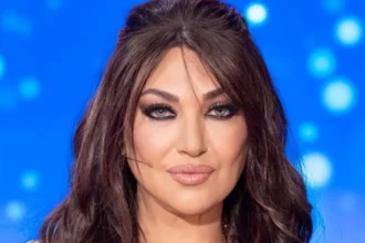 Η Καίτη Γαρμπή σε μια εντυπωσιακή AI δημιουργία με πλατινέ μαλλιά και αυτιά λαγού, να φοράει μια λευκή γούνα, περιτριγυρισμένη από κατάλευκους λαγούς με μπλε μάτια.