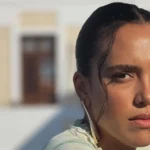 Η ηθοποιός Σάντυ Χατζηιωάννου ποζάρει χαμογελαστή και λαμπερή φορώντας ένα λευκό μπικίνι, με φόντο το καλοκαιρινό τοπίο στη Χαλκίδα.