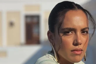 Η ηθοποιός Σάντυ Χατζηιωάννου ποζάρει χαμογελαστή και λαμπερή φορώντας ένα λευκό μπικίνι, με φόντο το καλοκαιρινό τοπίο στη Χαλκίδα.