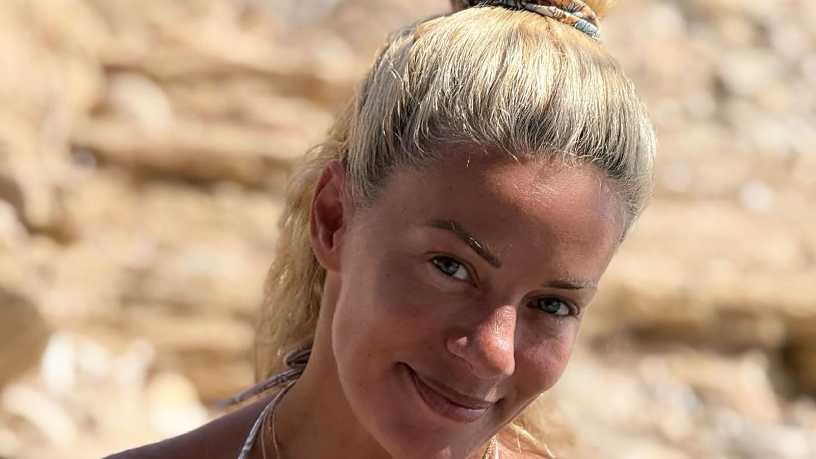 Η Ζέτα Μακρυπούλια χαμογελαστή δίπλα στη θάλασσα κατά την πρώτη της βουτιά