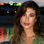 Η Χρύσα Μιχαλοπούλου ποζάρει το σούρουπο δίπλα στο κανάλι της Κοπεγχάγης, φοράει patterned πουκάμισο, μαύρη φούστα και ψηλοτάκουνα πέδιλα.