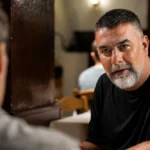 Ο Βασίλης Μπισμπίκης σε δραματικό στιγμιότυπο από το πρώτο τρέιλερ της σειράς Δυο μαύρα πουκάμισα.