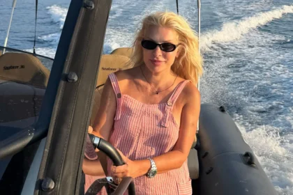 Ελένη Μενεγάκη χαμογελαστή στο τιμόνι φουσκωτού στις καλοκαιρινές διακοπές