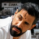 Ο ηθοποιός Γιώργος Παράσχος χαμογελάει μέσα από το δωμάτιο του Νοσοκομείου Αλεξάνδρα πριν ξεκινήσει τη θεραπεία του.