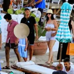 Η Κέιτι Πέρι με casual ρούχα, ψάθινο καπέλο και γυαλιά ηλίου κατευθύνεται προς φουσκωτό σκάφος στην παραλία της Ψαρρούς στη Μύκονο.