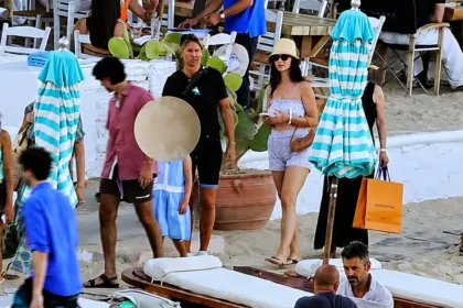 Η Κέιτι Πέρι με casual ρούχα, ψάθινο καπέλο και γυαλιά ηλίου κατευθύνεται προς φουσκωτό σκάφος στην παραλία της Ψαρρούς στη Μύκονο.